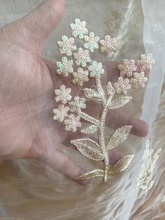 a person's hand holding some flowers on a plastic wrap around their thumb and fingers