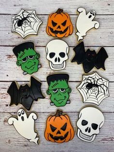 decorated cookies with halloween images on them and bats, pumpkins, and ghost heads