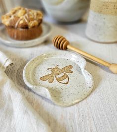 a plate with a bee design on it next to a cupcake and honey comb