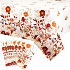 the table cloth is decorated with flowers and pumpkins on it, along with matching placemats