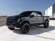 a black truck parked in front of a building