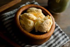 a wooden bowl filled with dough on top of a table