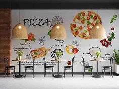 an empty restaurant with pizzas on the wall