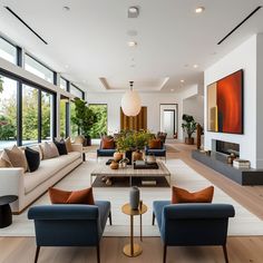 a living room filled with lots of furniture and large window covered area in front of it