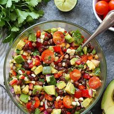 a bowl filled with black beans, avocado, tomatoes and cilantro