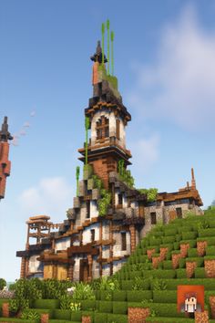 a very tall building sitting on top of a lush green hillside