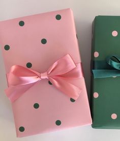 two wrapped presents with pink and green polka dots on them, one has a bow