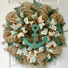 a wreath with an anchor on the front and green ribbon around it's center