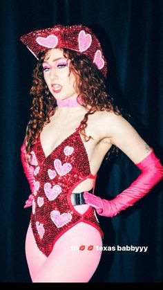 a woman in a red and pink costume with hearts on her body is posing for the camera