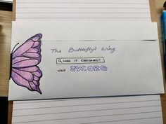 an envelope with a purple butterfly on it next to a blue pen and some writing paper