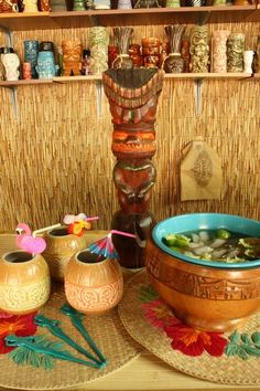 bowls and vases are sitting on the table in front of a wall with many items