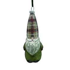 a glass ornament hanging from a wire on a white background with red and green decorations