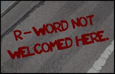 the words r - word not welcome here are painted on an asphalt surface