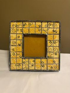 a yellow and black photo frame sitting on top of a table