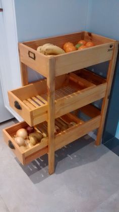 a wooden shelf with drawers holding fruit and vegetables