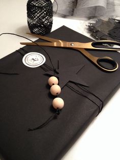 a pair of scissors sitting on top of a black cloth next to some balls and beads