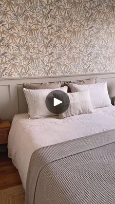 a bed sitting in a bedroom next to a wall with a flower pattern on it