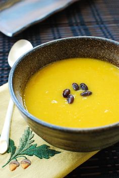 a bowl of soup with raisins in it on a napkin next to a spoon