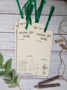 three tags that say wishes for baby with green ribbons on them and some scissors next to it