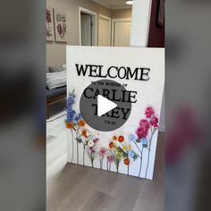 a welcome sign with flowers painted on it