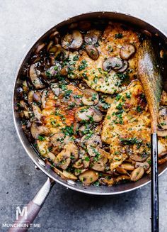 a skillet filled with chicken, mushrooms and parsley