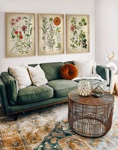 a living room filled with furniture and pictures hanging on the wall above it's coffee table