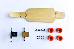 a wooden board with orange knobs and some screws on the side, along with other parts