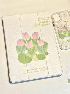 two notebooks sitting next to each other on top of a white table with pink flowers