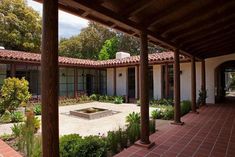 an outdoor courtyard with brick pavers and potted plants