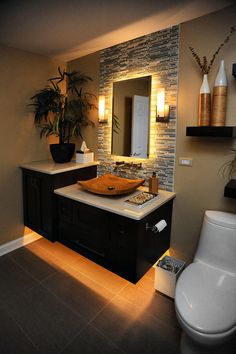 a bathroom with a toilet, sink, and mirror in it's center area