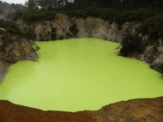 a green lake surrounded by trees and rocks