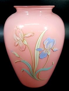 a pink vase with flowers painted on it