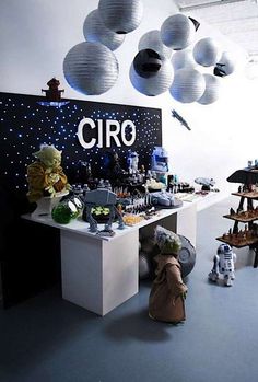 a star wars themed birthday party with lights and decorations on the ceiling, including paper lanterns