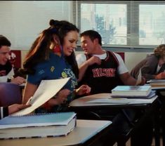 a group of people sitting at desks in a classroom