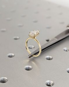 a gold ring with a diamond on it next to a pair of scissors