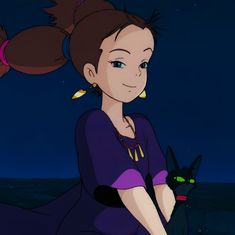 a woman sitting on top of a rock next to a black cat in the dark