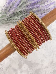 Rumana bangle set. Comes in multiple colors. All comes with 12 colored metal bangles with gold dots. 4 antique size Kada. 4 rhinestone bangles and 4 antique churi. Maroon Bangles Set, Red Bangles Set Bridal, Red Bangle Bracelets With Zari Work, Red Bohemian Bangle For Festive Occasions, Red Bohemian Bangle For Festive Season, Red Zari Work Bangle Bracelets, Red Zari Work Bangle Bracelet, Festive Red Bohemian Bangle, Festive Beaded Bangle For Festivals