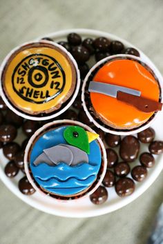 three cupcakes with chocolate candies in the shape of dolphins on them, and an orange rubber duck