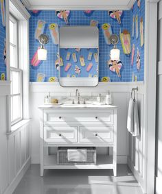 a bathroom with blue and white wallpaper, two sinks and a mirror on the wall