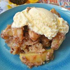 a blue plate topped with an ice cream covered apple crisper dessert and a scoop of vanilla ice cream