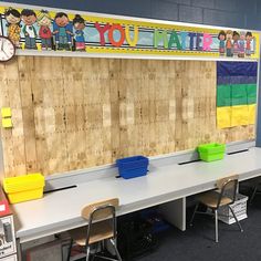 an empty classroom with wooden boards on the wall and plastic buckets on the desk