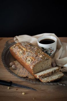 a loaf of bread sitting on top of a plate next to a cup of coffee