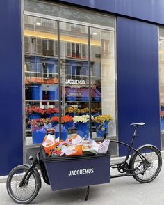 a bicycle parked in front of a flower shop