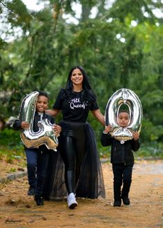 a woman and two children holding balloons in the shape of letters that spell out 30