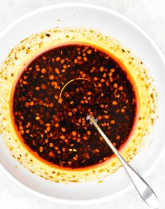 a white bowl filled with sauce on top of a table