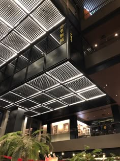 the inside of a building with lights and plants