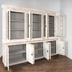 an old white cabinet with glass doors and shelves