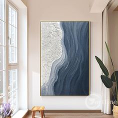 an abstract painting hangs on the wall above a wooden bench in front of a window