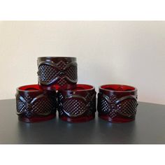 four red glass cups sitting on top of a table