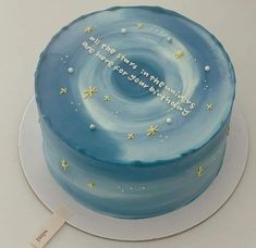 a blue cake with writing on it sitting on top of a white plate